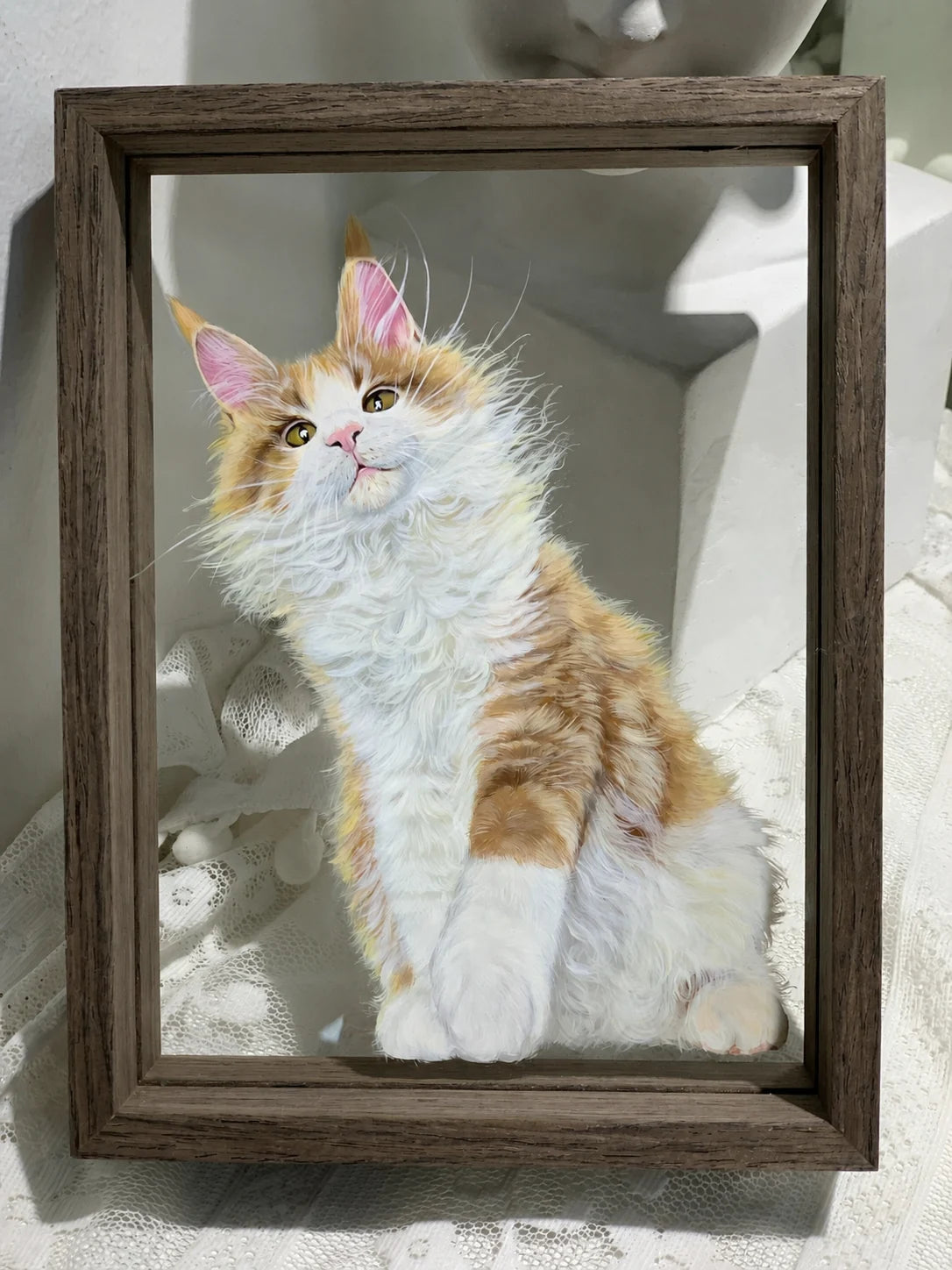 Finished orange-and-white cat glass painting displayed on a wall