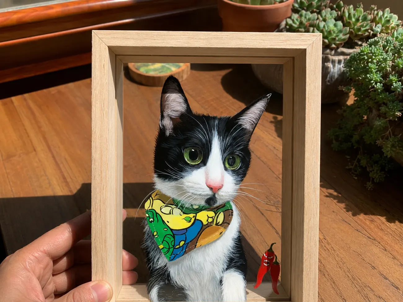 Finished tuxedo cat glass portrait held in a light wood frame